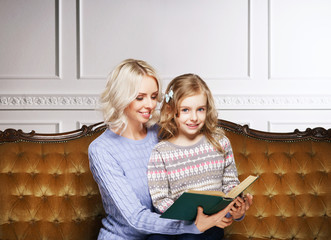 Mother and daughter reading a book at home