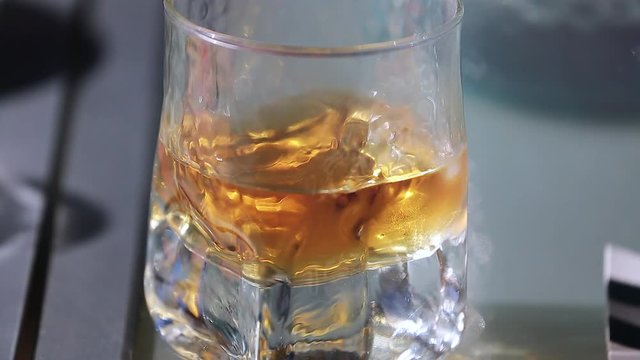 Glass of Whiskey With Ice On Table
