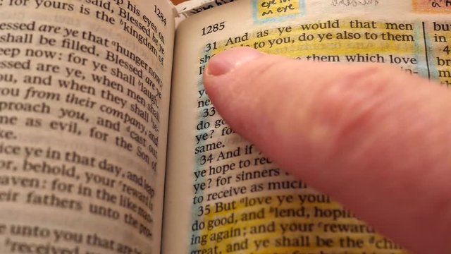 Closeup dolly shot of reading Holy Bible do unto others