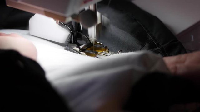 A woman uses a sewing maching in her house on project