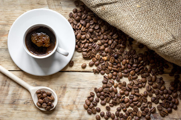 coffee beans with coffe cup on wooden table top view