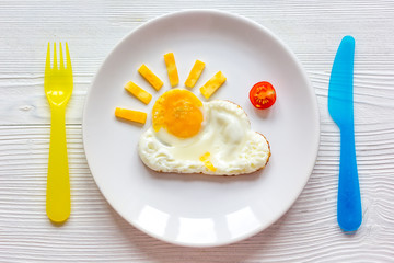 sunshine fried eggs breakfast for kid on wooden background