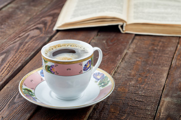 Coffee cup on dark wood table with book