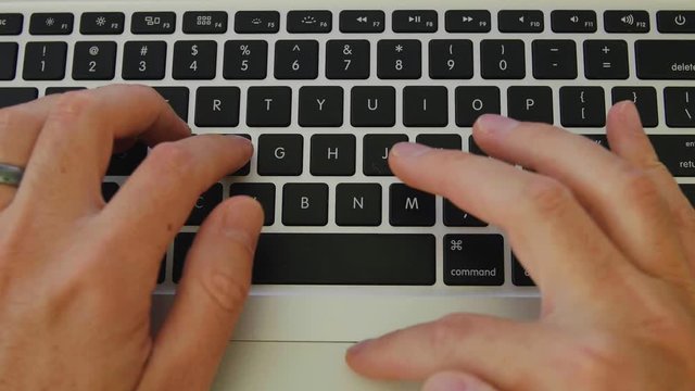 Man typing on a laptop computer closeup