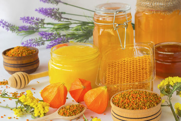 Honey in glass jars. Honeycombs and pollen