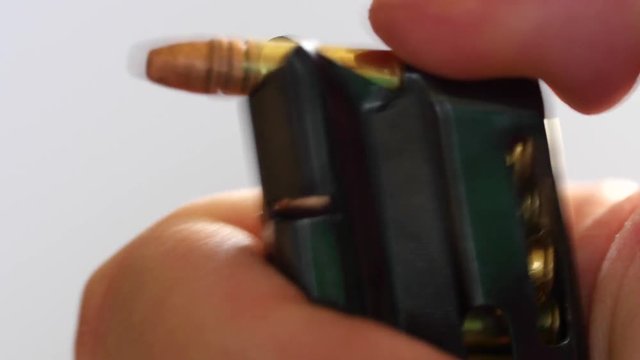 Closeup man unloads bullets from magazine