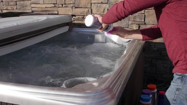 Man putting chemicals into a hot tub
