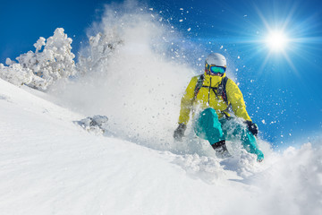 Skier skiing downhill in high mountains - obrazy, fototapety, plakaty