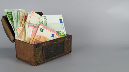 Geldtruhe / Geldschatulle / Schatzkiste mit viel Geld / Textfreiraum