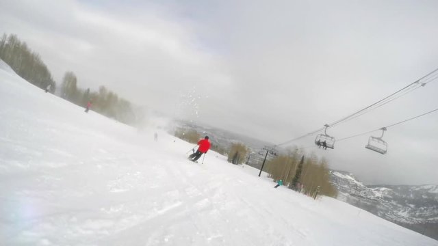 Slow motion shot of skier skiing fast down the mountain resort hill