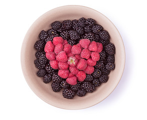 Ceramic plate with heart shaped berries isolated on the white background with clipping path. Top view.
