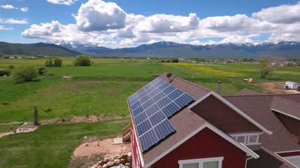 Aerial shot of flying over house with solar panels in spring