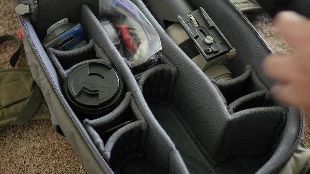 Man puts camera gear into pack