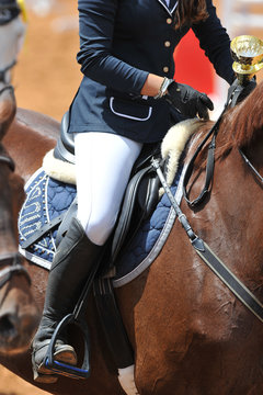 A close up view of the professional female jockey rides on horseback.