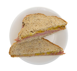 Applewood smoked ham sandwich on a plate top view isolated on a white background.