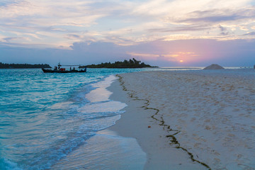 Coast of a tropical island with sand at sunset, Maldives