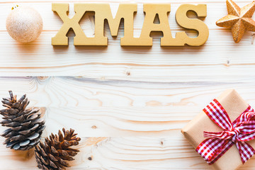 Christmas decoration with word xmas,pine cones and gift on wooden background with copyspace, top view, flat lay.
