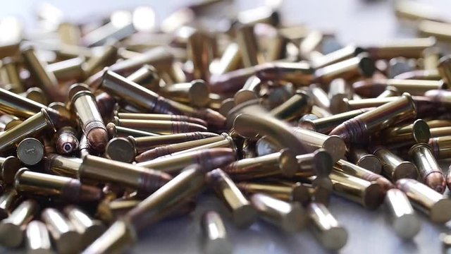 Slow motion of a dolly shot of pile of .22 ammunition bullets