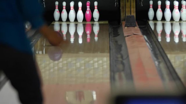 Woman bowls in small town bowling alley