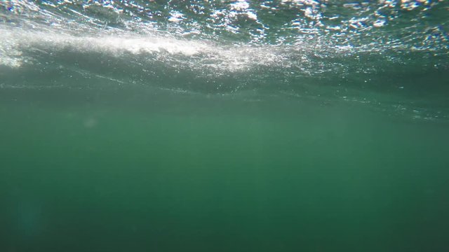 An underwater shot of large rough ocean waves on surface