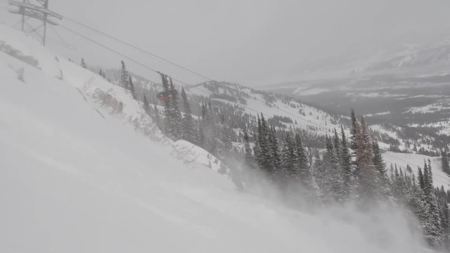 Man and woman ski powder at resort in Jackson Hole