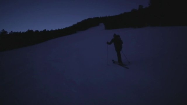 Skier hikes up mountain in the dark