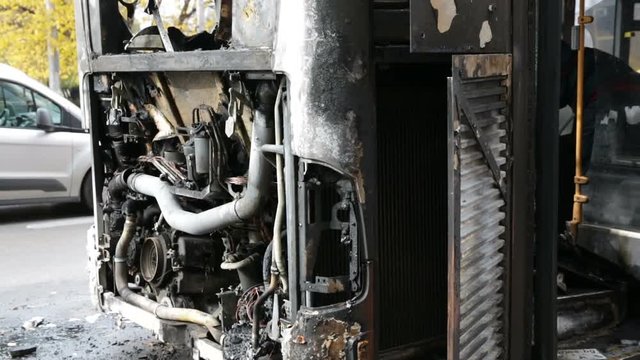 Burnt public traffic bus is seen on the street after caught in fire during travel and extinguished by firefighters.