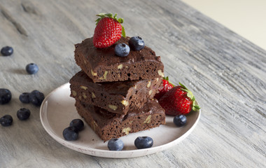 Chocolate - cherry brownie served with blueberry and strawberry 