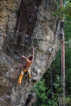 Rock climber ascending a challenging cliff. Extreme sport climbing. Freedom, risk, challenge, success. 