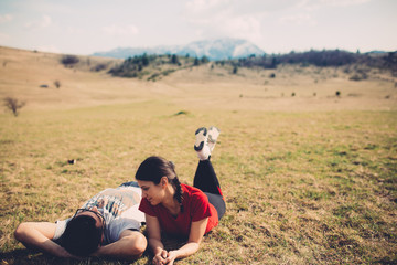Loving couple resting in nature. Spending free time together. Enjoying the holidays. Lying on a meadow.Pair spending time in nature.Camping and having picnic