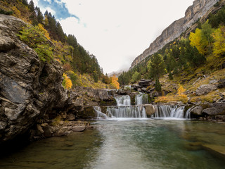 Colorful valley in autumn with a waterfall