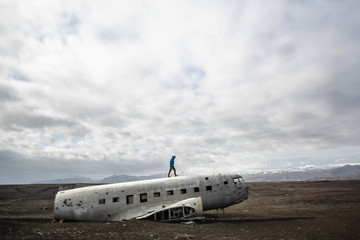 Man walk on epic plane wreck on the black beach in south Iceland