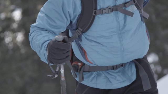 man hiking up steep slope in winter with warm gear on