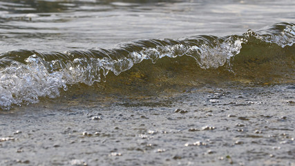 Calm sea or lake waves breaking on shore as background resource
