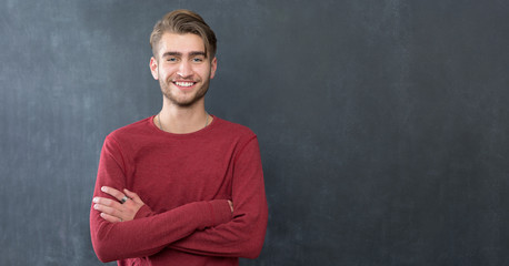 sexy fashion man or student dressed casual smiling against chalk