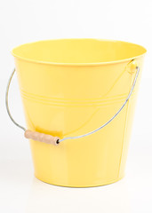 Yellow  iron/metal bucket/pail/container with handle isolated on white background. Colorful kid child toys. Garden equipment.