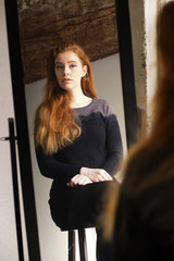 Red Haired Woman in Black Dress Looking at Herself in a Mirror