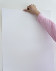 Man is holding a piece of blank white paper, presentation background.