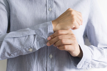 Woman dressing up and fastening buttons on shirt at home.