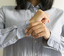 Woman dressing up and fastening buttons on shirt at home.