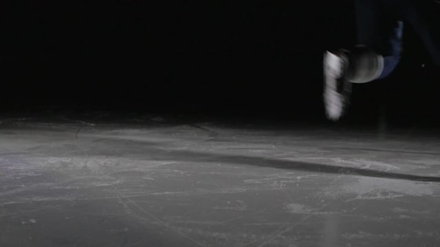 Hockey player make ice sparkles on high speed braking. Motion blur. Legs view only