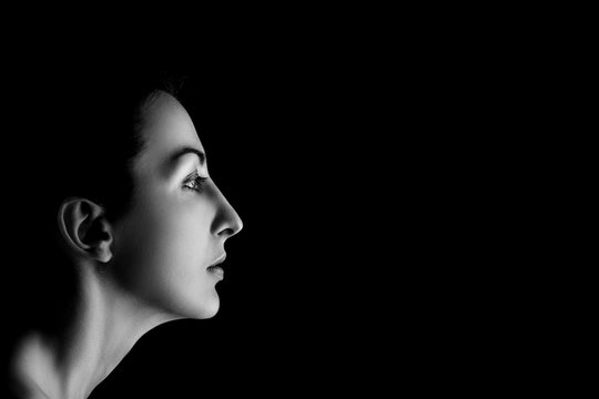 serious female profile on black background with copyspace