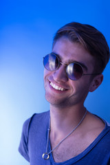 Portrait of an attractive young man laughing against blue backgr