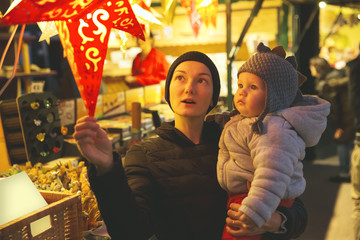 Fototapeta na wymiar Happy family spend time at a Christmas street market and fair