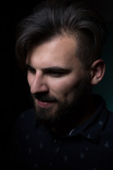 Attractive business man on dark studio background.