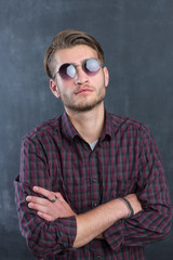 Portrait of a relaxed young man with checkered shirt and sunglas