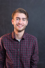 Obraz premium sexy fashion man or student dressed casual smiling against chalk