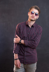 Portrait of a relaxed young man with checkered shirt and sunglas