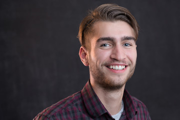 Portrait of a charming young man in checkered shirt smiling