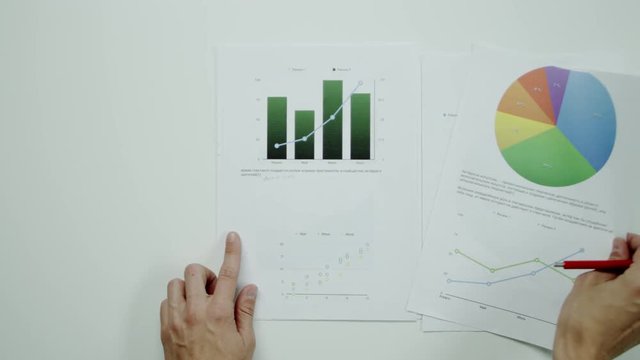 Man comparing graphic charts.
